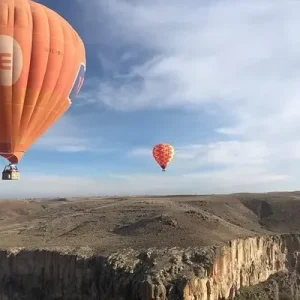 Hot air balloon soaring over Ihlara Valley at sunrise