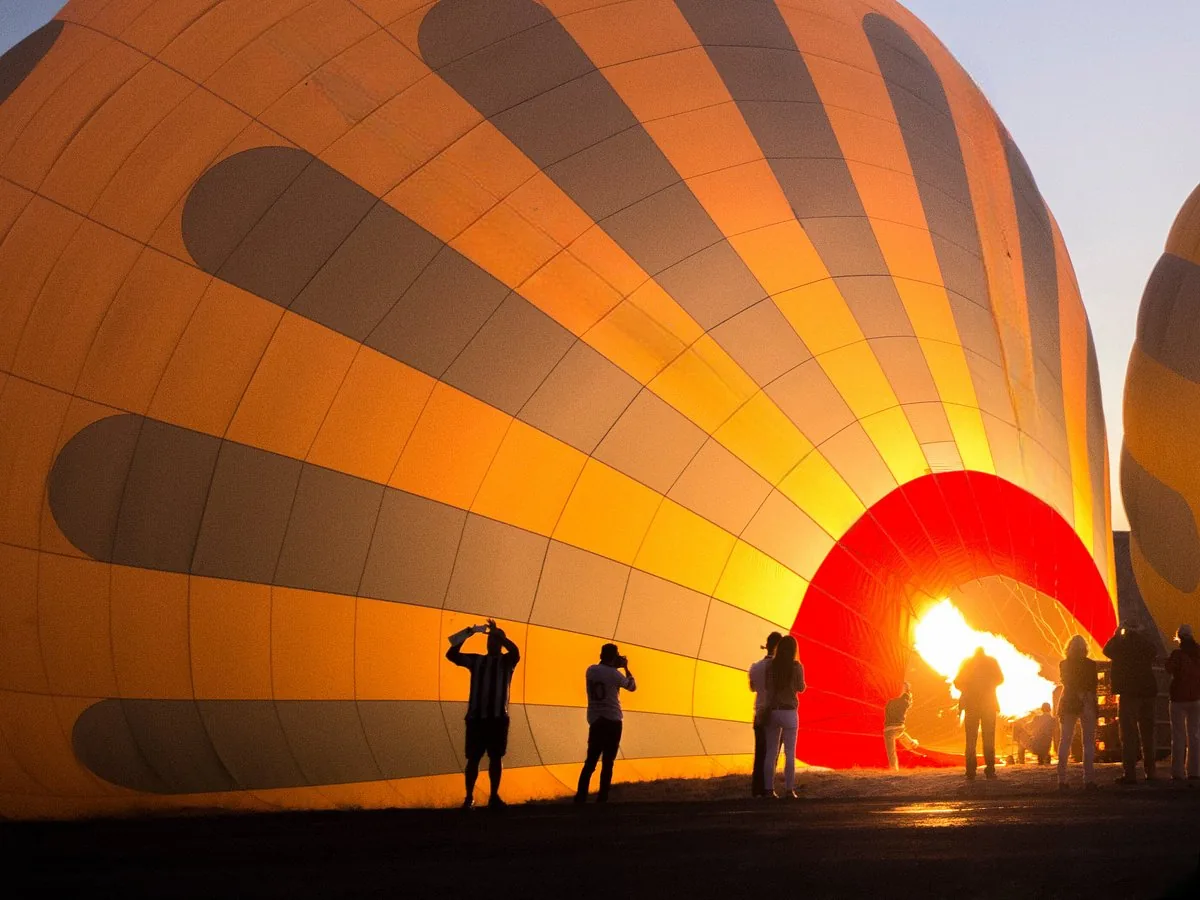 Hot air balloon inflation silhouettes before Cappadocia sunrise