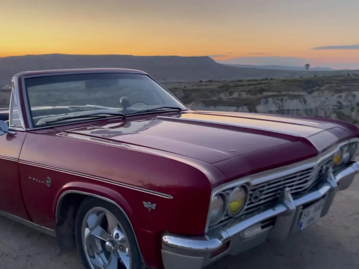 Burgundy classic convertible photographed at sunrise in the Cappadocia landscape