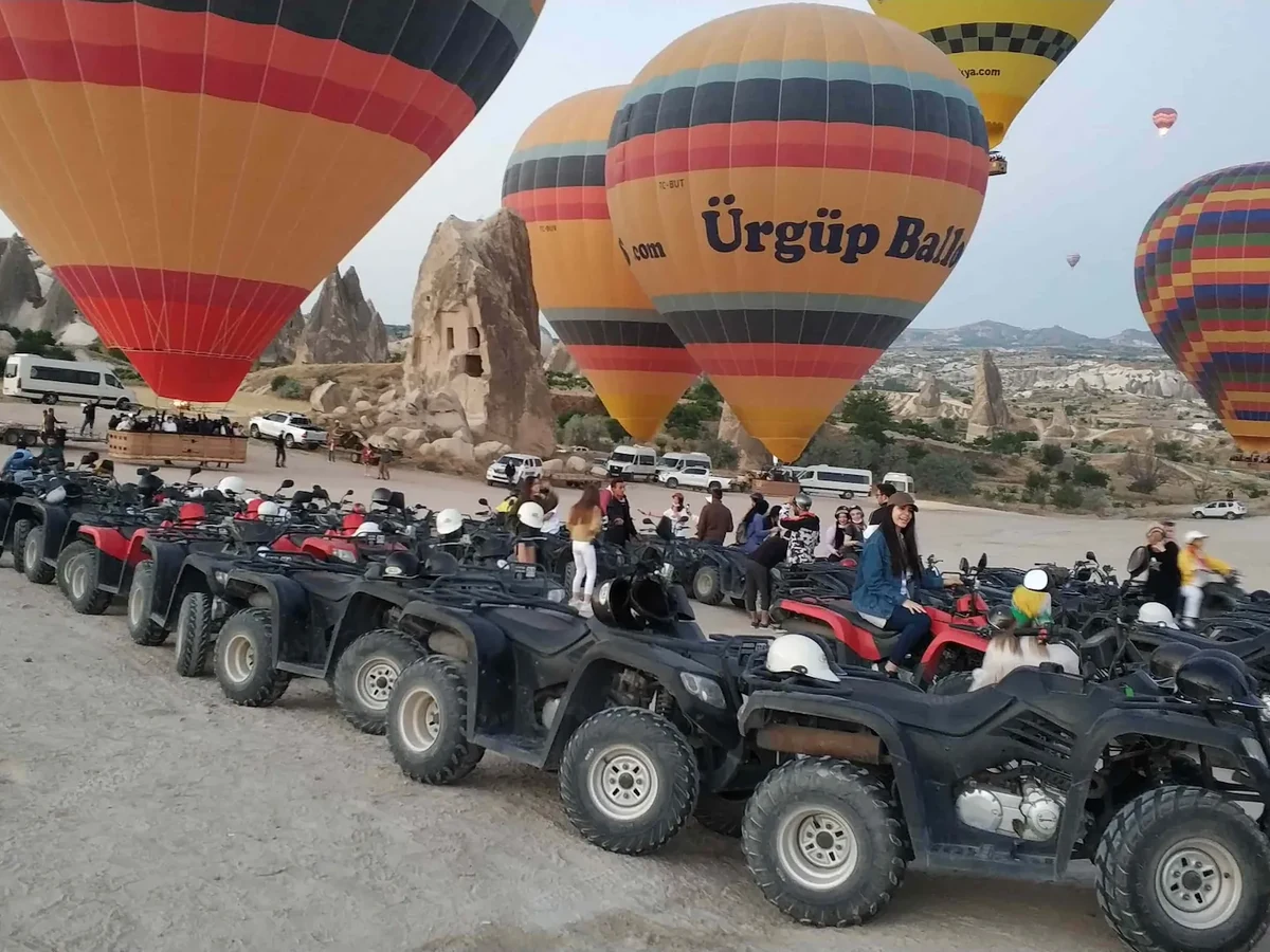 ATV group gathered beside hot air balloons during a Cappadocia sunrise tour