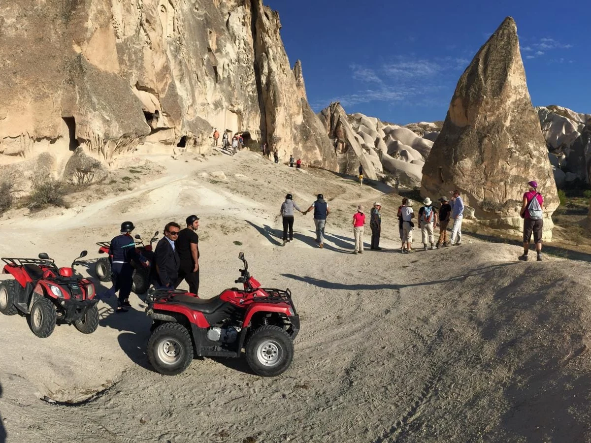 ATV tour group stopping near Cappadocia fairy chimneys during the day