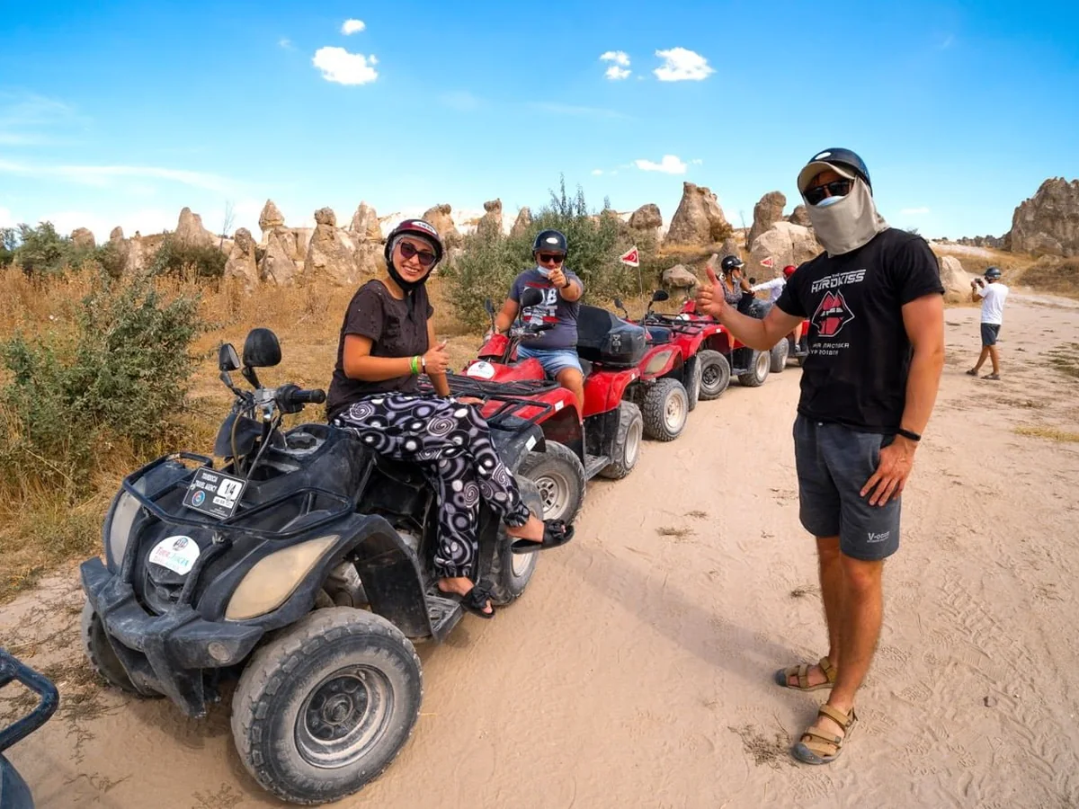 Guests and guide posing with quad bikes during a Cappadocia ATV tour