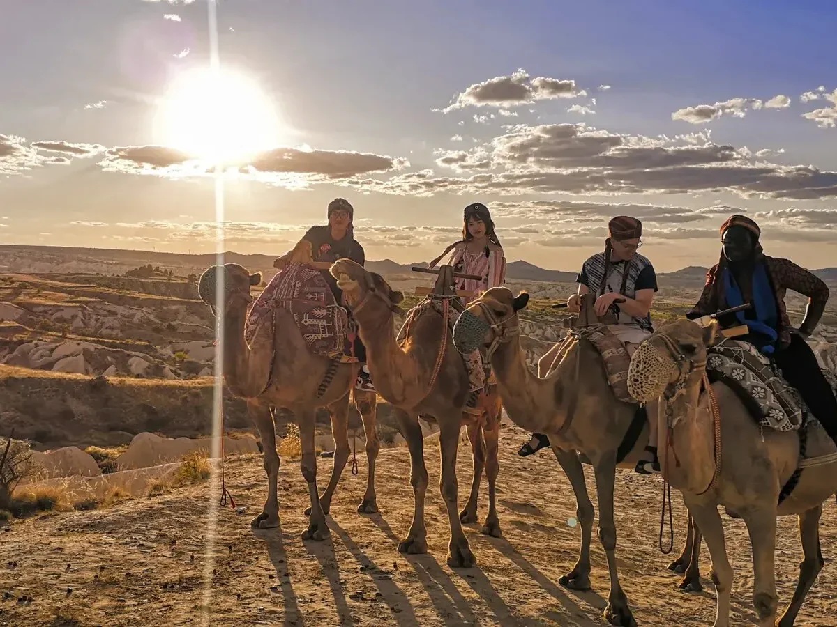Camel riding group enjoying golden sunset views across Cappadocia