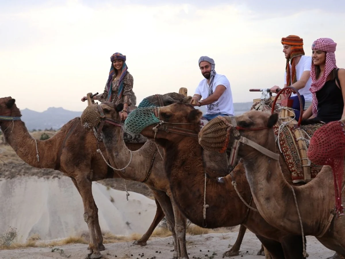 Travellers riding decorated camels during a guided Cappadocia safari