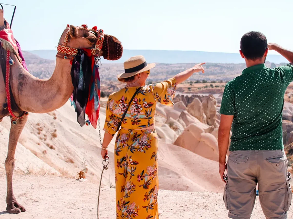 Traveller posing beside a decorated camel during a Cappadocia photo stop