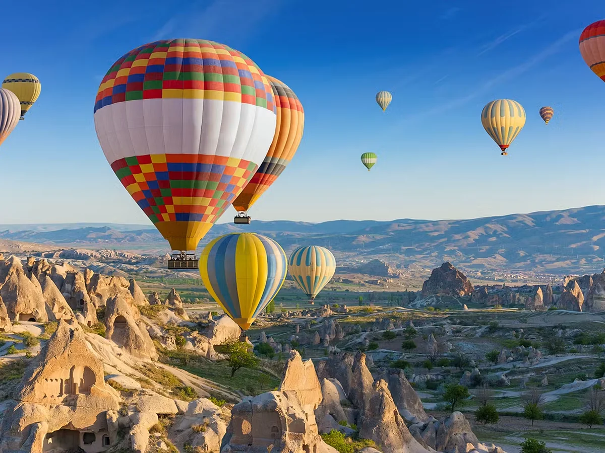 Colorful hot air balloons flying above Cat Valley in Cappadocia at sunrise