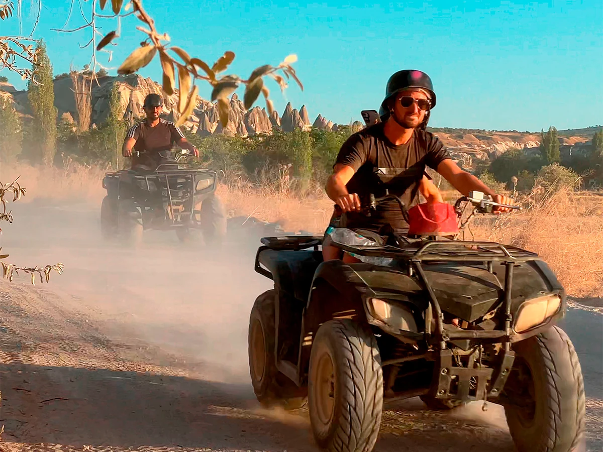 ATV rider crossing a dusty Cappadocia trail during a daytime tour