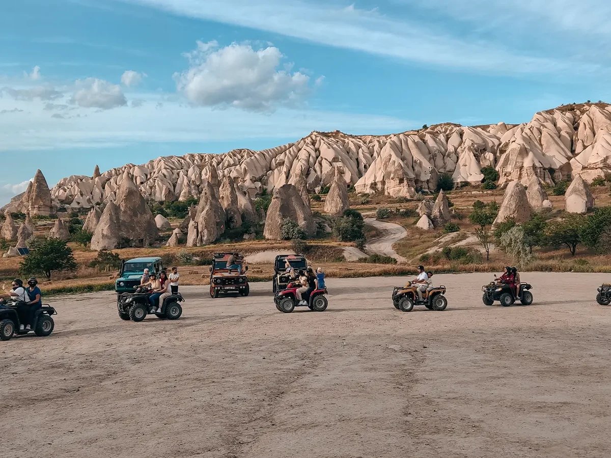 ATV group riding across a wide Cappadocia valley landscape