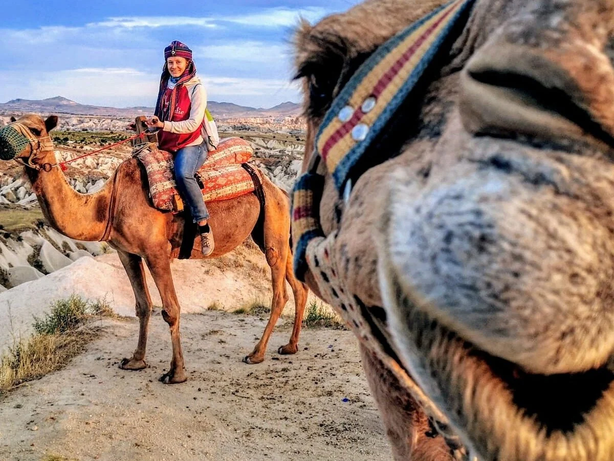 Woman riding a camel during a daytime safari in Cappadocia