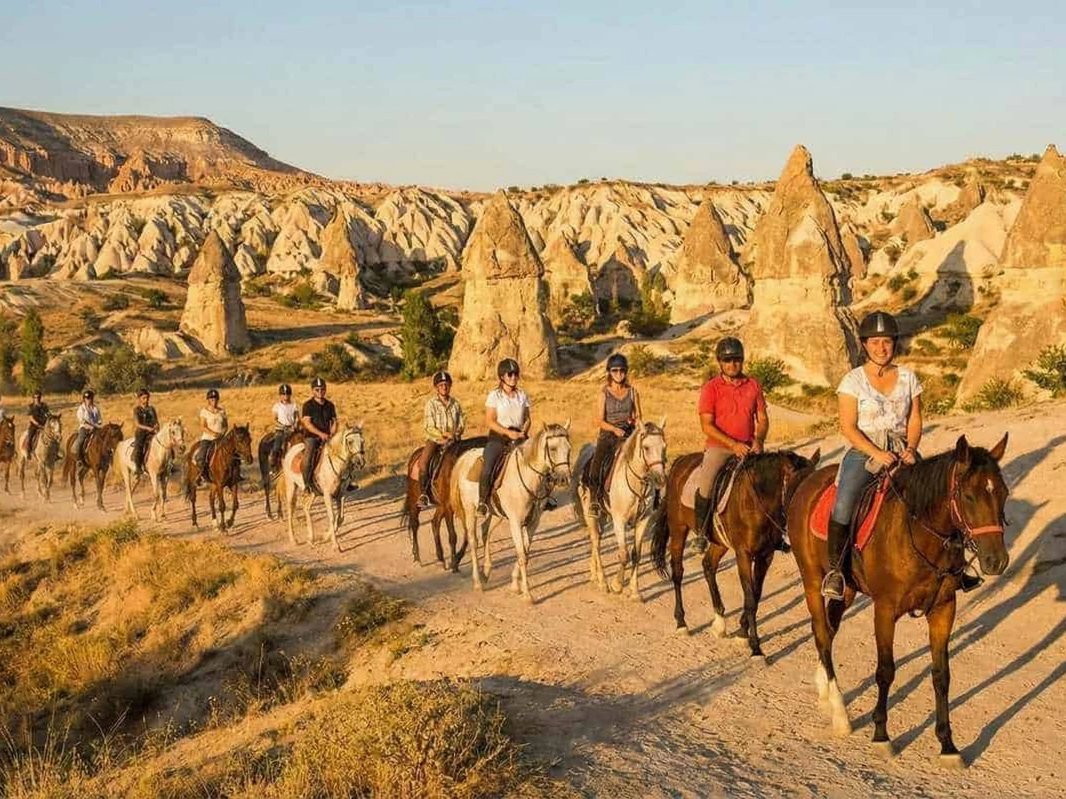 Horse riding group following a scenic trail through Cappadocia