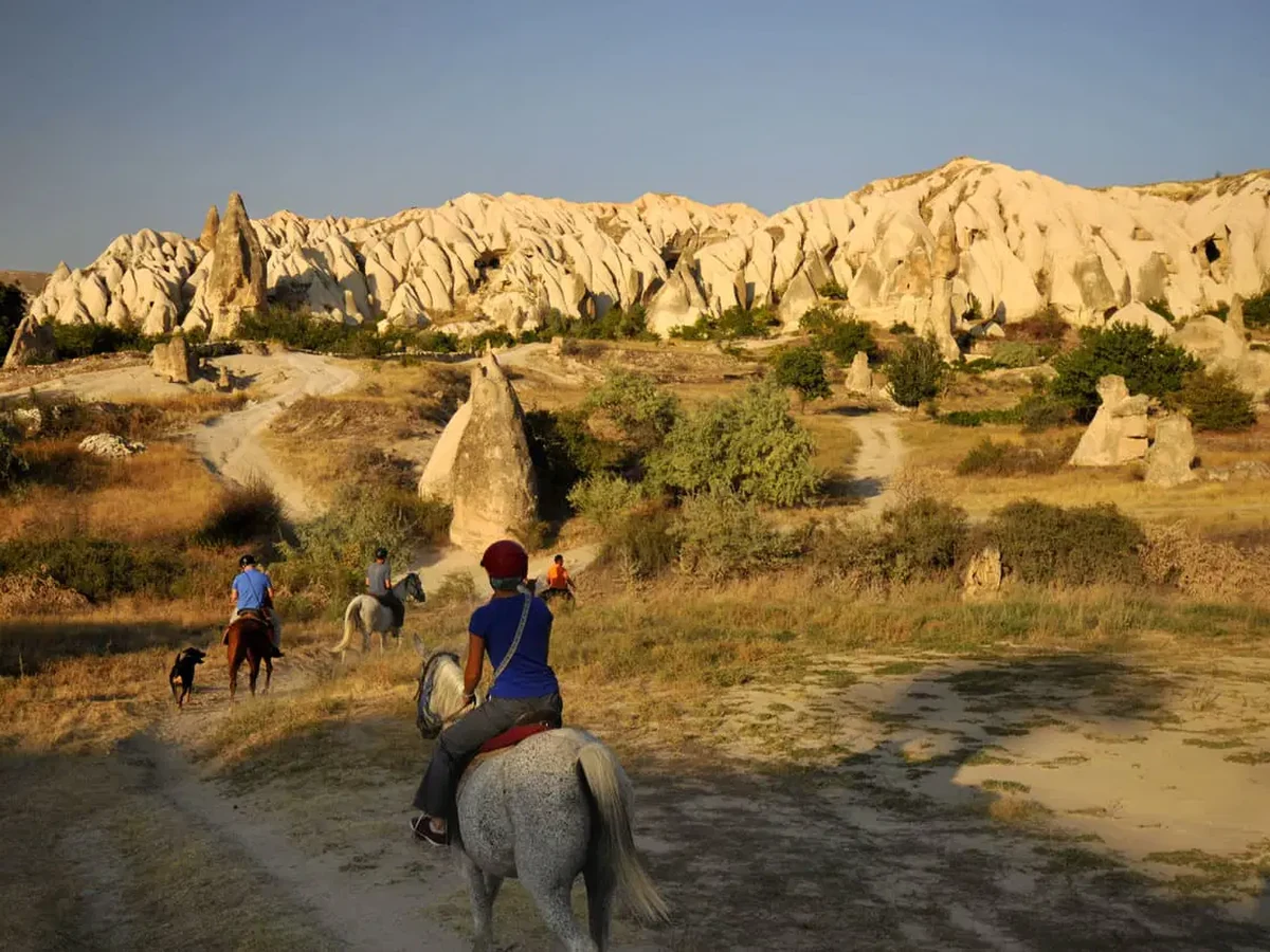 Horse riders exploring a Cappadocia valley before sunset