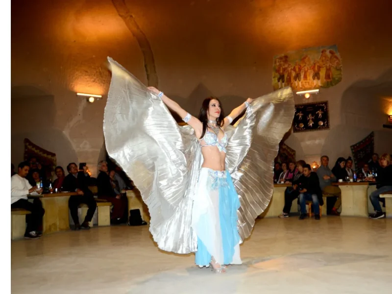 Belly dancer in a white costume performing at a Cappadocia Turkish Night Show