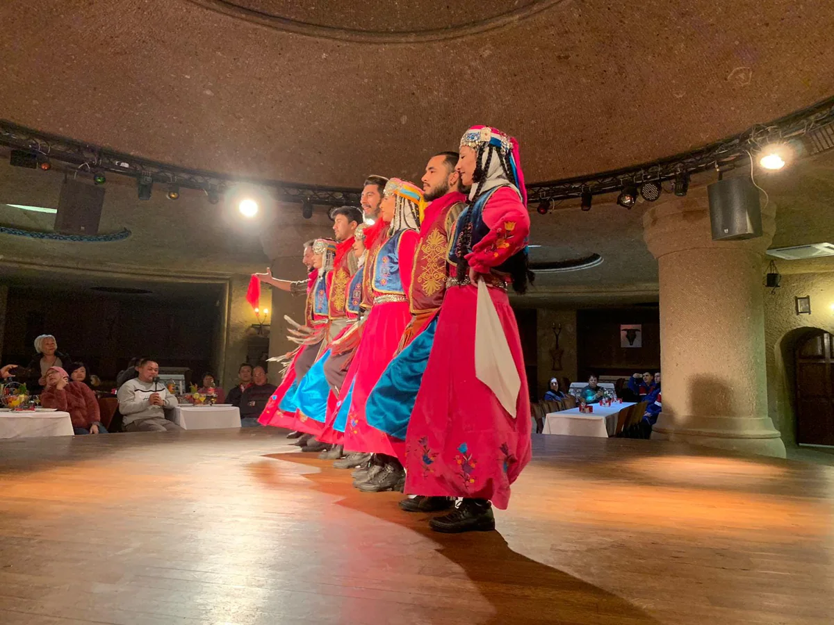 Folk dancers performing during a Turkish Night dinner experience in Cappadocia