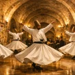 Whirling dervishes performing a traditional Sema ceremony in a historic Cappadocia caravanserai