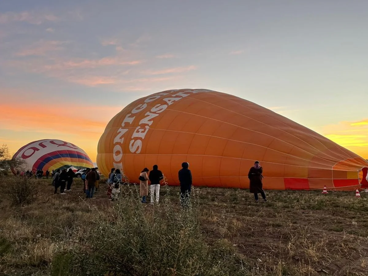Passengers watching hot air balloons inflate in Cat Valley before a Cappadocia flight