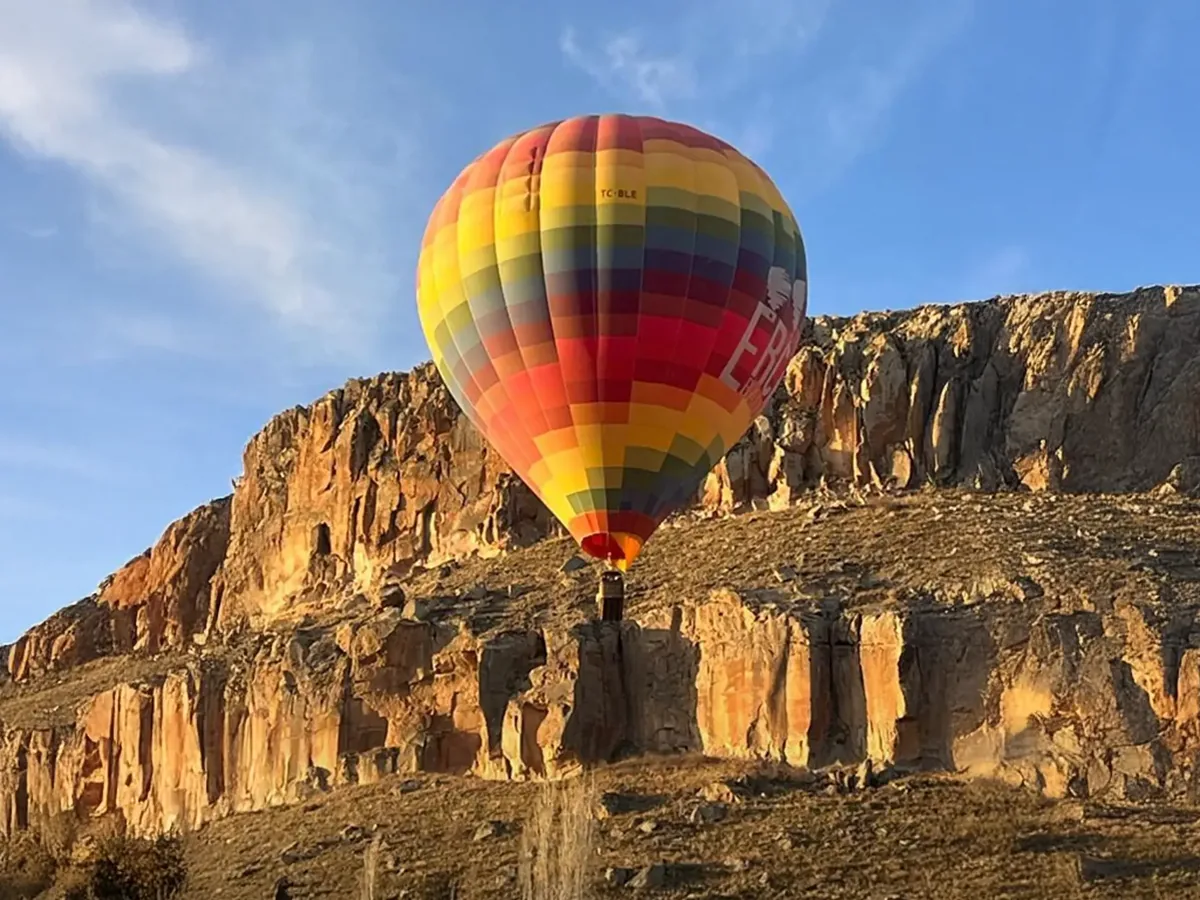 Colorful hot air balloon over Ihlara Canyon cliffs in Cappadocia