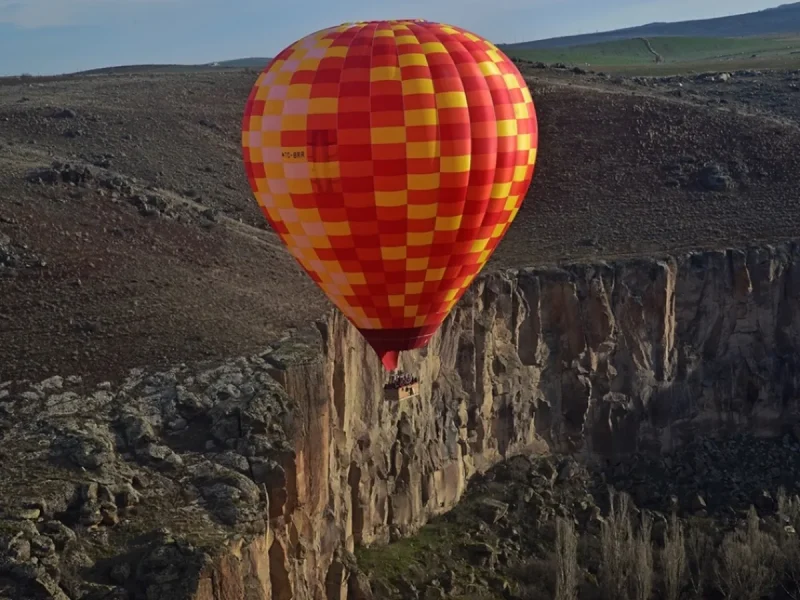 Colorful hot air balloon over Ihlara Valley cliffs in Cappadocia