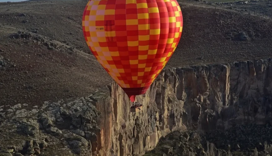 Colorful hot air balloon over Ihlara Valley cliffs in Cappadocia