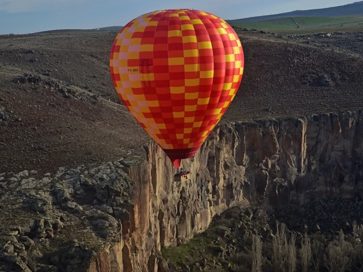 Colorful hot air balloon over Ihlara Valley cliffs in Cappadocia