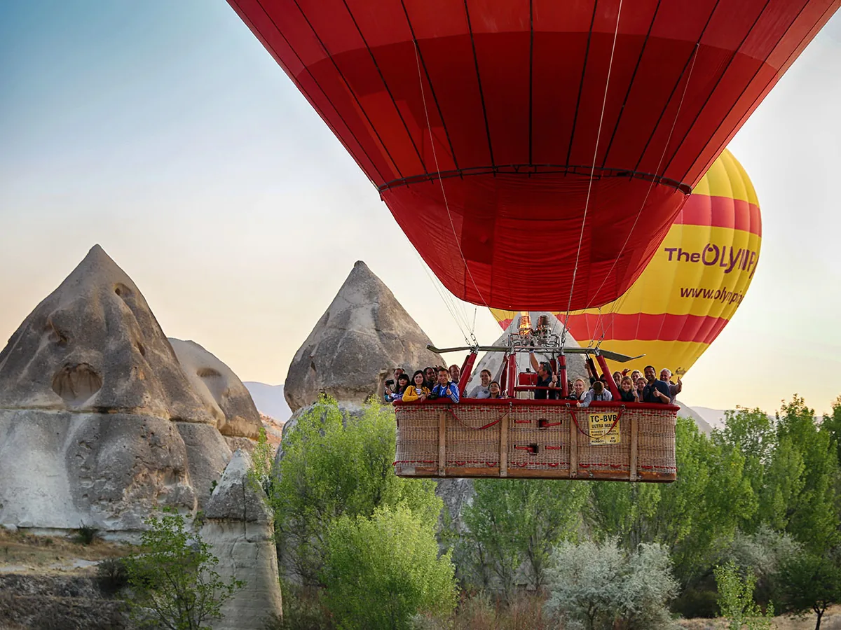Hot air balloon floating past fairy chimneys in Cappadocia