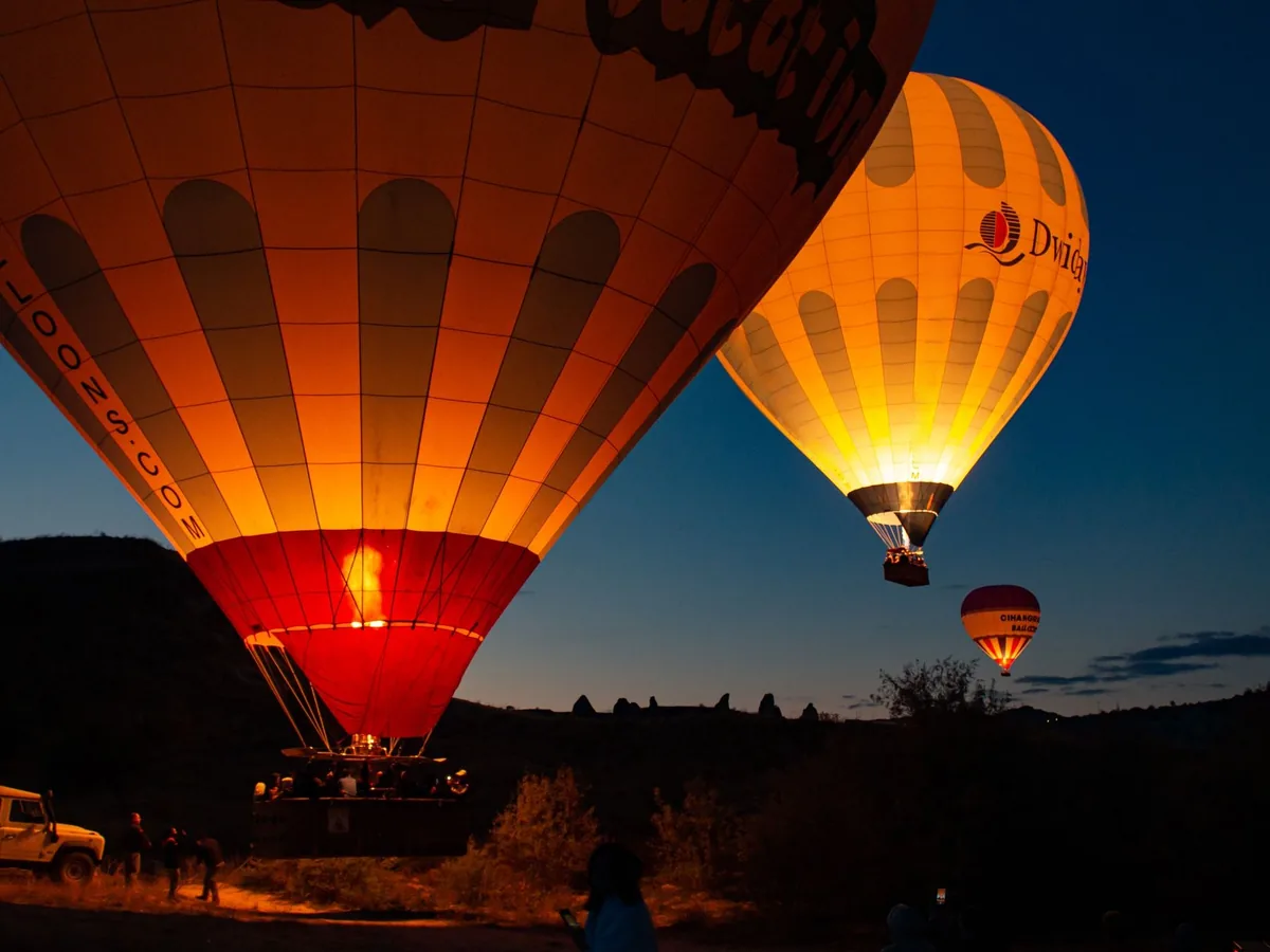 Hot air balloons glowing in Cappadocia twilight