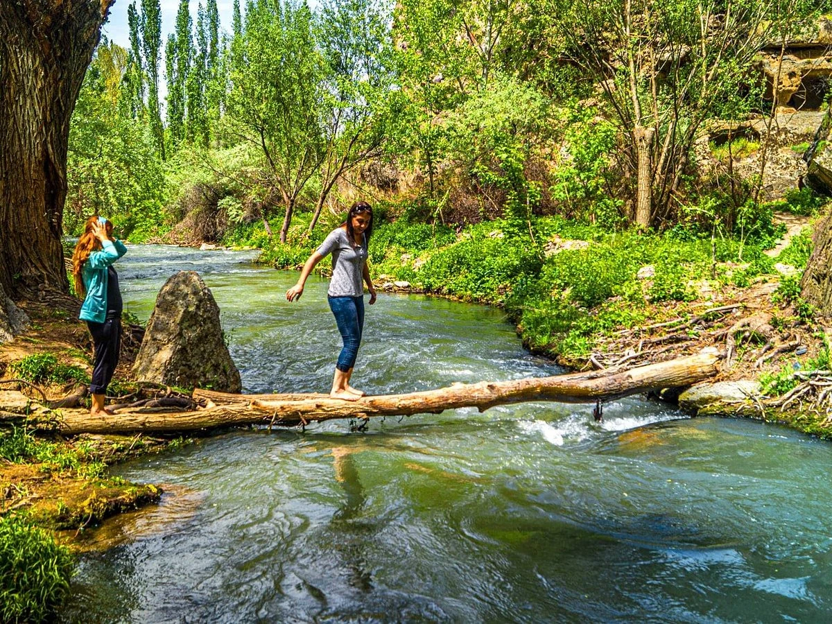 Visitors crossing a stream in Ihlara Valley during a private Cappadocia Green Tour