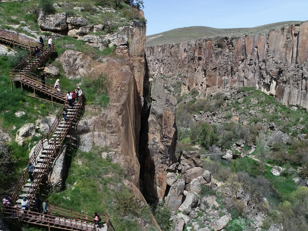 Visitors walking down the wooden stairway into Ihlara Valley in Cappadocia