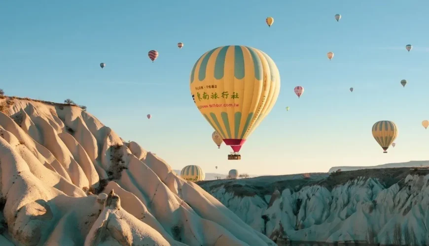Peaceful hot air balloon floating over Cappadocia rock cliffs