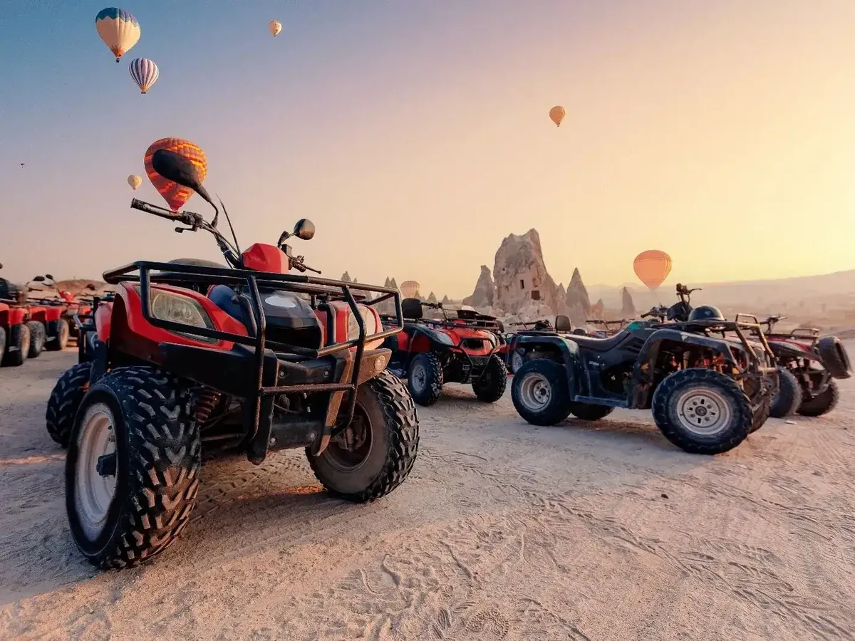 Quad bikes prepared for a sunrise ride in Cappadocia as balloons fill the sky