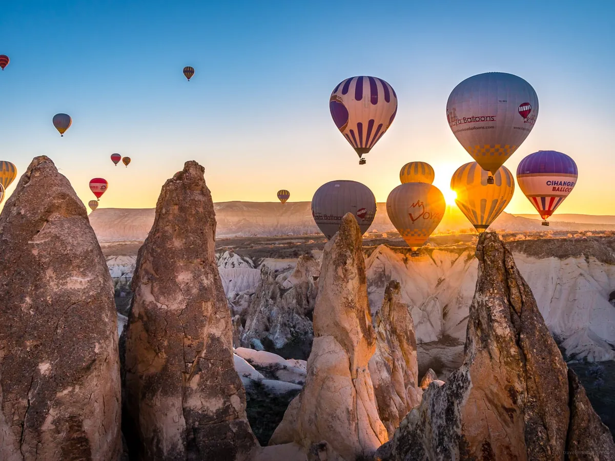 Sunrise hot air balloons floating between fairy chimneys in Cappadocia