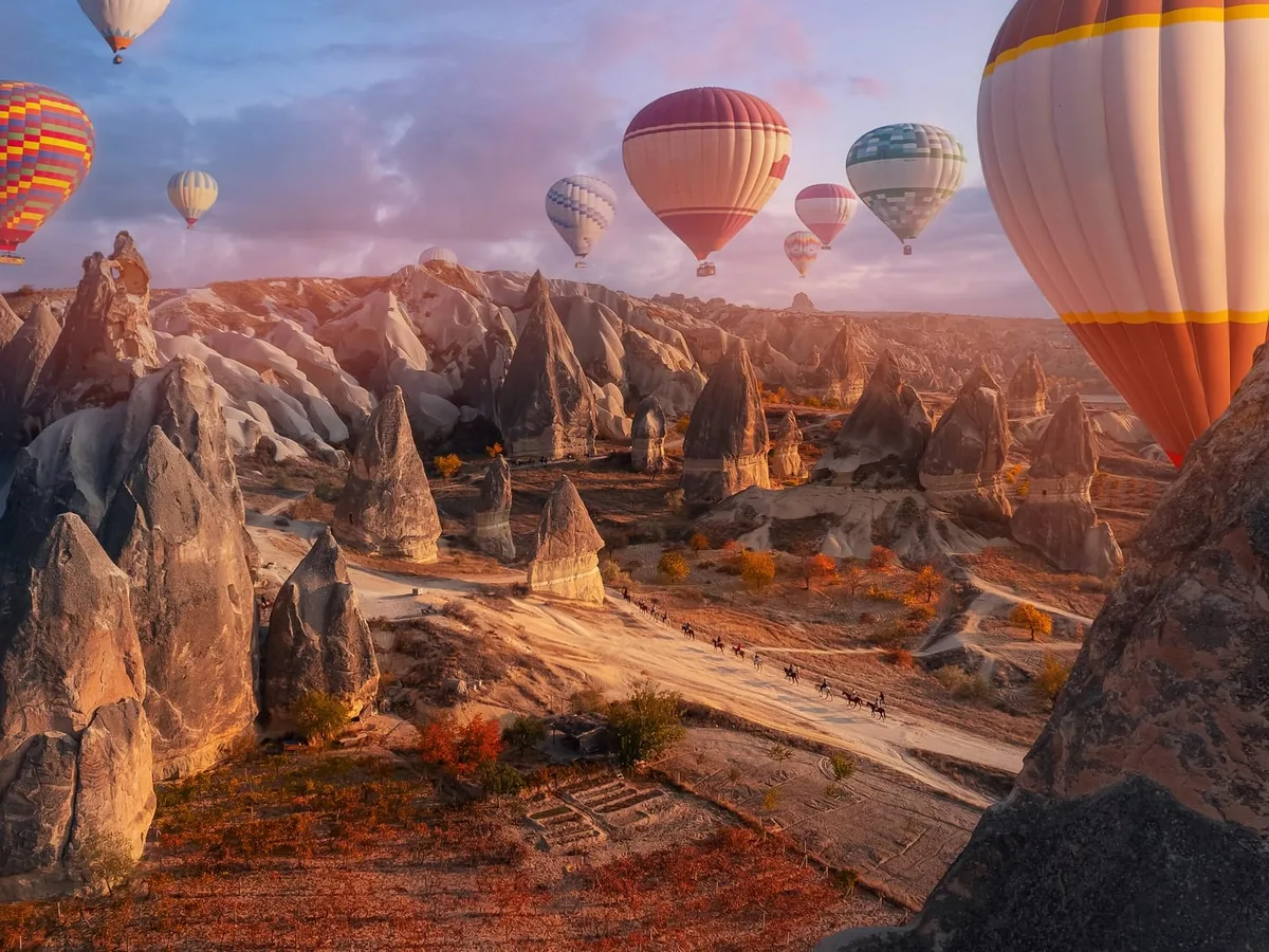 Sunrise hot air balloons over ancient Cappadocia rocks