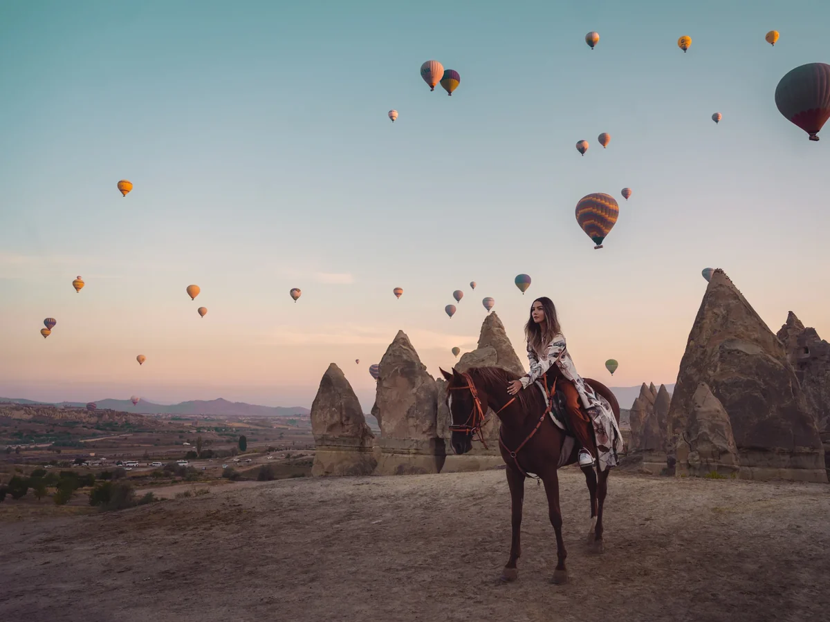 Horse safari group riding through Cappadocia during the golden sunrise