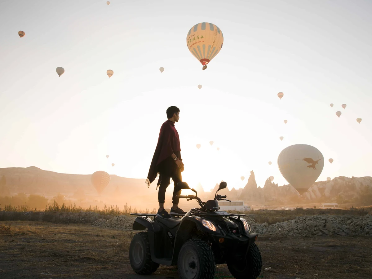 Traveler standing on a quad bike during a Cappadocia sunrise balloon tour
