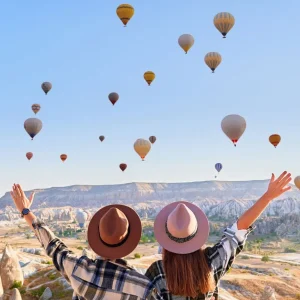 Travelers enjoying a sky filled with hot air balloons in Cappadocia