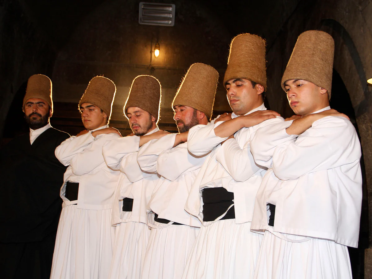 Whirling dervishes standing in prayer during a ceremony in Cappadocia